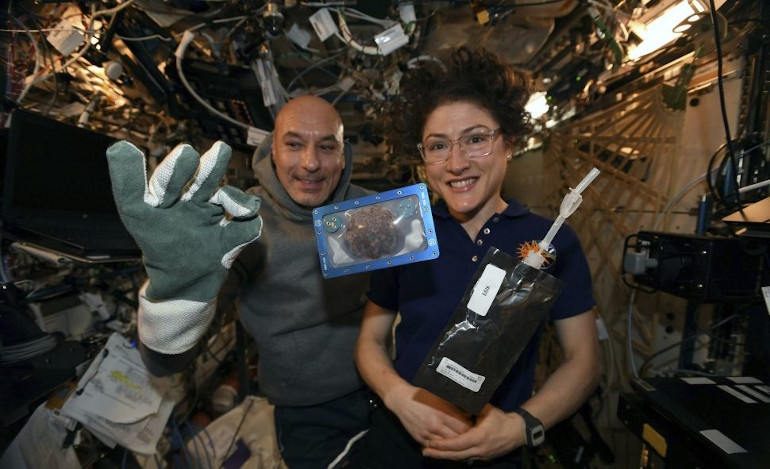 Οι αστροναύτες Λούκα Παρμιτάνο και Κριστίνα Κοχ παρουσιάζουν με καμάρι ένα από τα σφραγισμένα μπισκότα τους