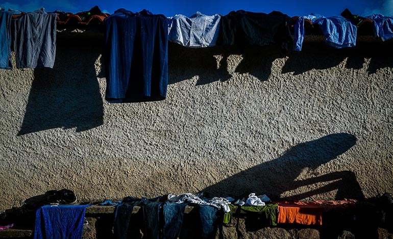 Μετανάστες έχουν απλώσει ρούχα έξω από εκκλησία της Συκαμιάς στη Λέσβο στις 6 Μαρτίου